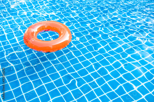 Slika na platnu Orange pool float, ring floating in a refreshing blue swimming pool