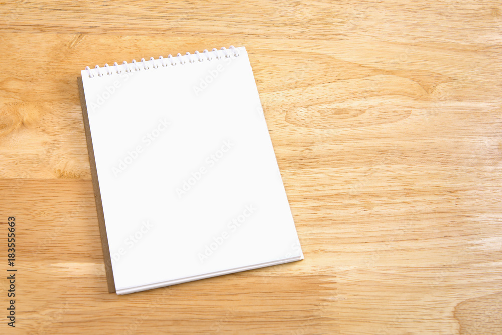 Blank spiral notebook on wood background Blank spiral notebook on wood background