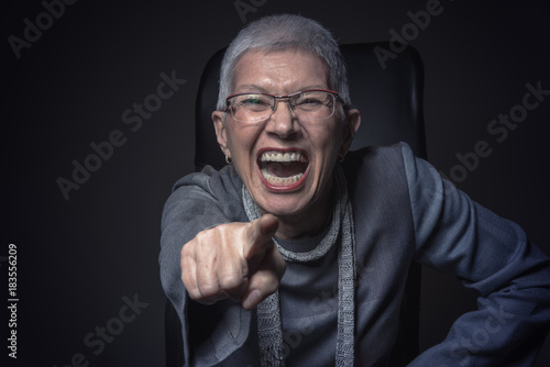 Obraz na plátně Senior elderly woman pointing finger, screaming with rage, placing the blame on