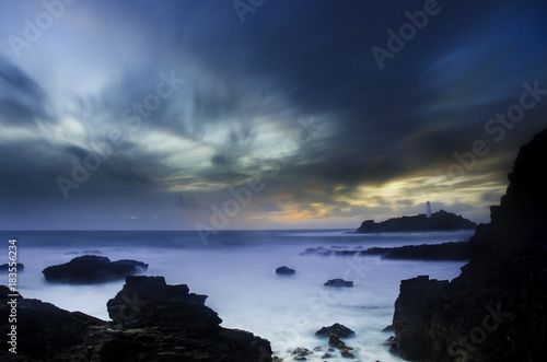 A long exposure of the rocky coast of Godrevy, Cornwall, England at sunset