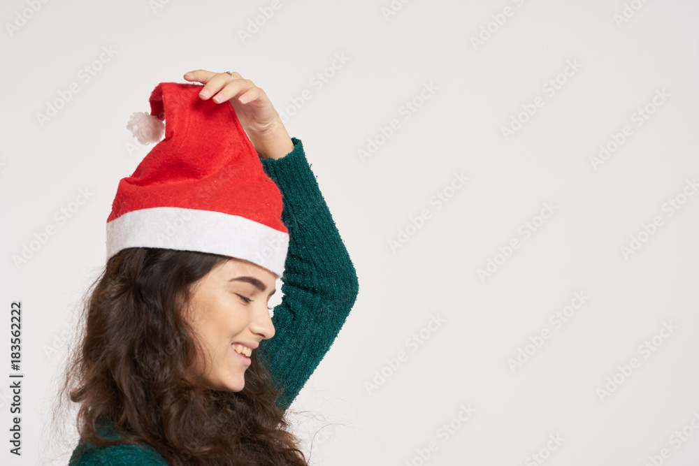 woman on a light background holds a New Year's cap on her head, free space for copying, new year woman on a light background holds a New Year's cap on her head, free space for copying, new year