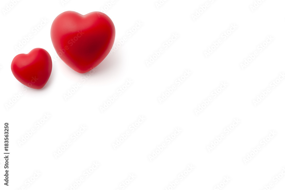 Big and Small Red Rubber Hearts on White Background Copy Space