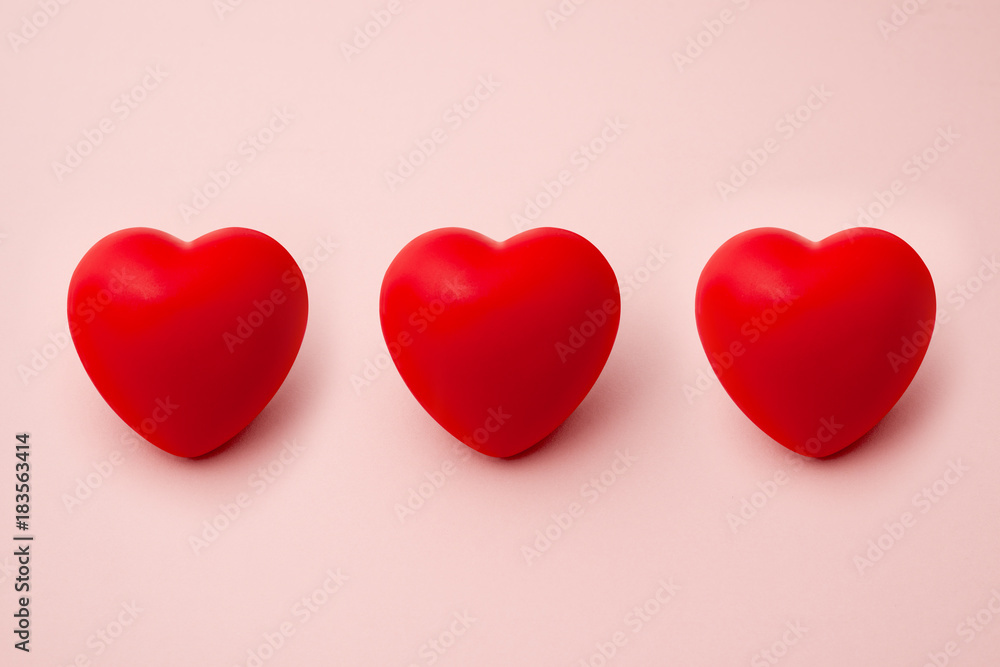 Three Red Hearts in a Row on Pink Background