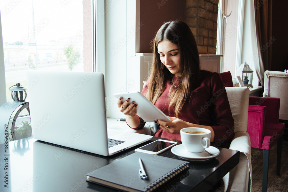 Young attractive woman sitting in a cafe in the morning before her work and planning tasks for the whole day. Beautiful lady talking on the phone and discussing business strategies with her colleague. Young attractive woman sitting in a cafe in the morning before her work and planning tasks for the whole day. Beautiful lady talking on the phone and discussing business strategies with her colleague.