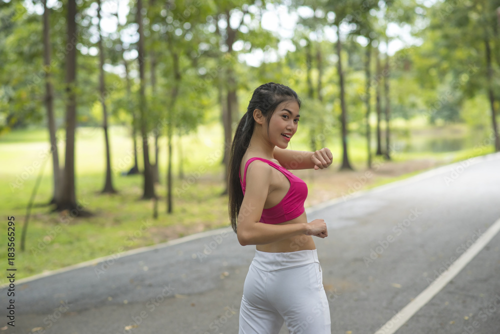 The girl is warming the body before jogging in the morning The girl is warming the body before jogging in the morning