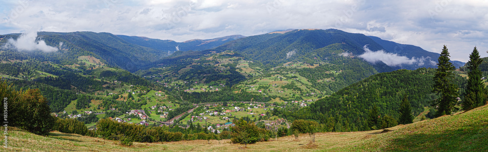 Carpatian mountains village at green forest panorama