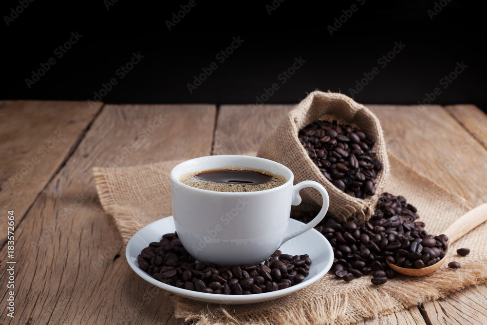 coffee cup and coffee beans on old wood plank background. coffee cup and coffee beans on old wood plank background.