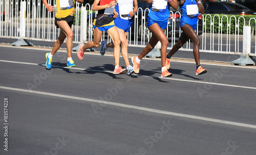 female and male marathon runners running on city road