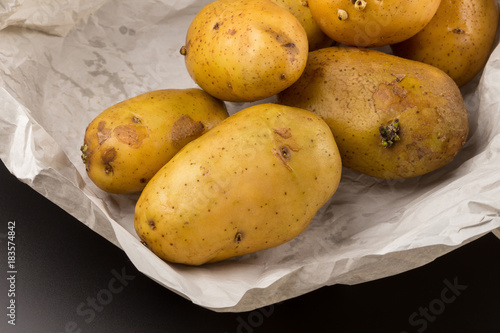 Uncooked fresh potatoes isolated on a Black background