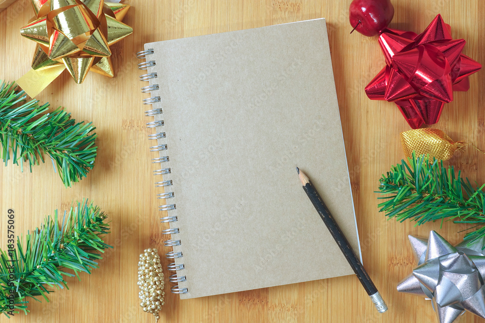 Brown book with pencil and christmas decoration on wooden table Brown book with pencil and christmas decoration on wooden table