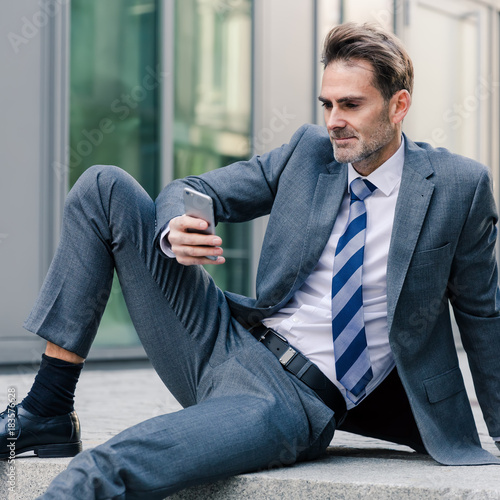 businessman sitting on stairs in an office park