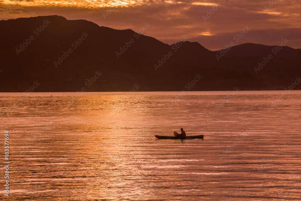 Sunset Sunrise with reflections at Lake Toba, Samosir Island, Indonesia.