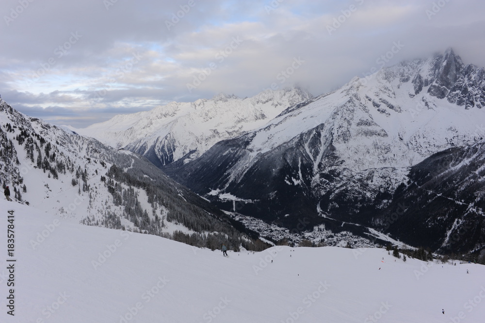 Panorama of French Alps with mountain ranges covered in snow and clouds in winter