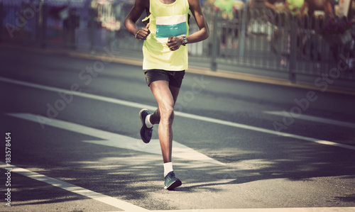 marathon runner legs running on city road