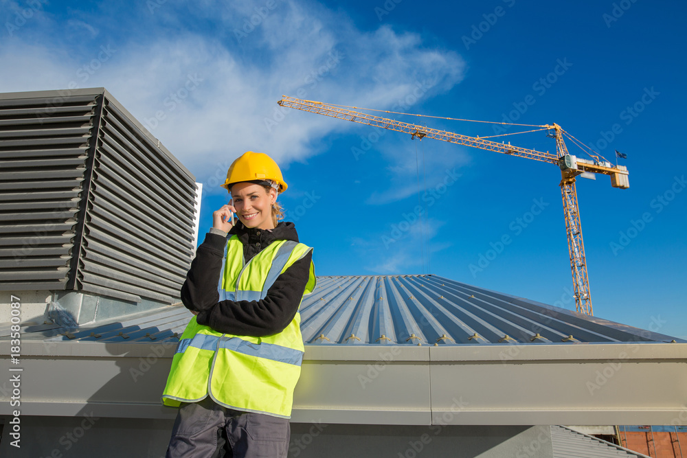 female ingineer with hardhat using electronics on construction roof female ingineer with hardhat using electronics on construction roof