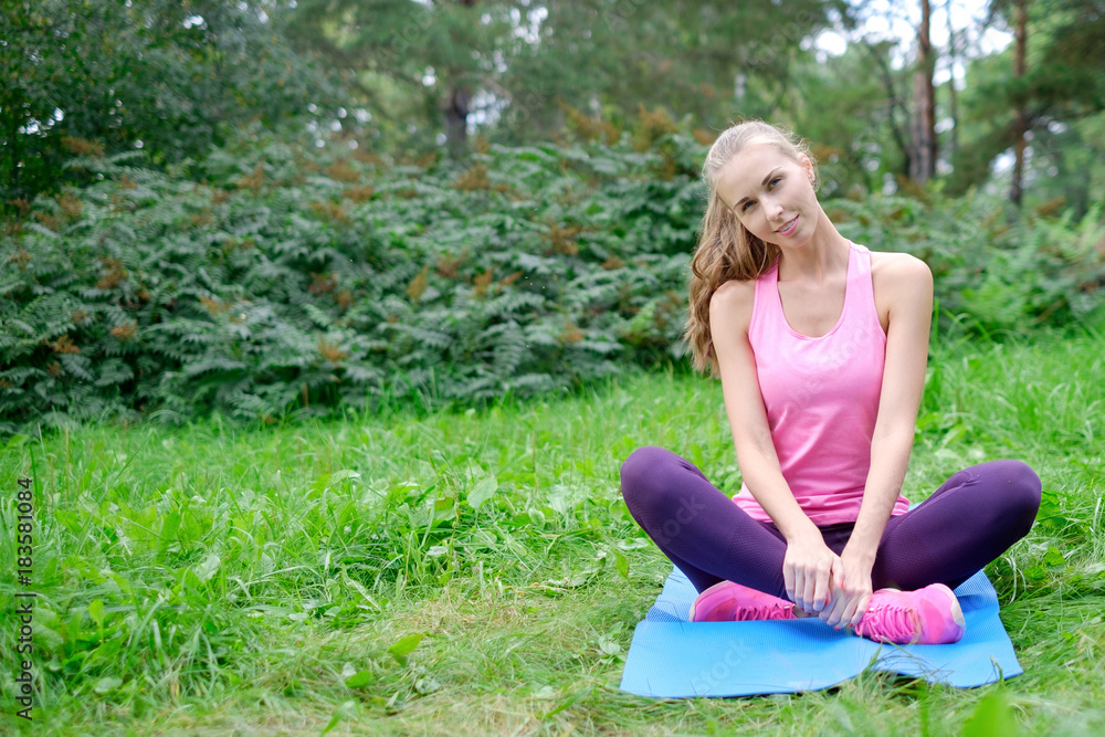 Obraz premium Beautiful sport woman doing stretching fitness exercise in city park at green grass. Yoga postures