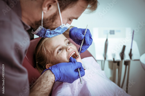 Smiling little girl at dentist office  for exam.