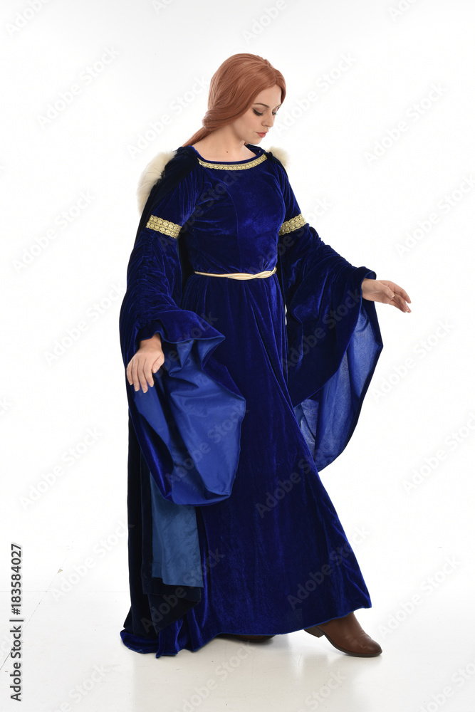 full length portrait of girl wearing long blue velvet gown and fur lined cloak, standing pose on white background. full length portrait of girl wearing long blue velvet gown and fur lined cloak, standing pose on white background.