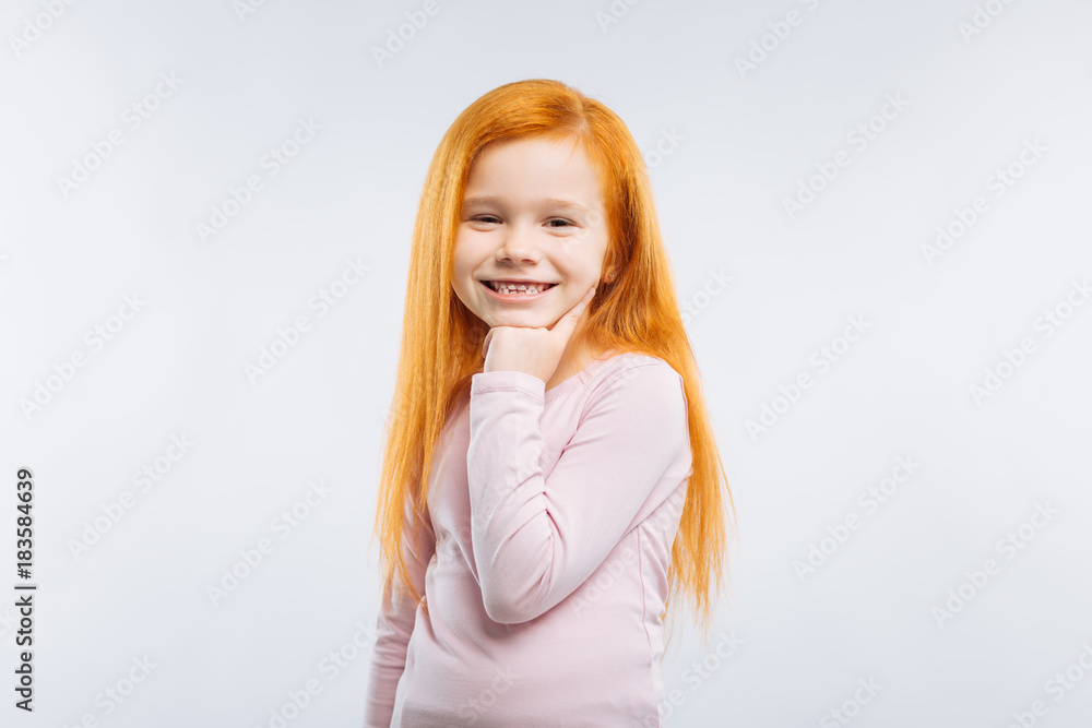 Moment of happiness. Charming kid keeping smile on her face and touching her chick while looking at camera Moment of happiness. Charming kid keeping smile on her face and touching her chick while looking at camera