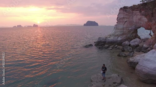 photographer take picture by drone in front of the hole in the cape  during sunset time.Leam Jamookkwy or Buffalo Nose cape is in Thalane Krabi photo