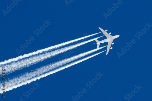 Huge Airplane big four engines aviation airport contrail clouds.