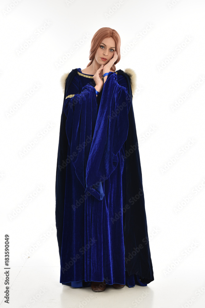 full length portrait of girl wearing long blue velvet gown and fur lined cloak, standing pose on white background. full length portrait of girl wearing long blue velvet gown and fur lined cloak, standing pose on white background.