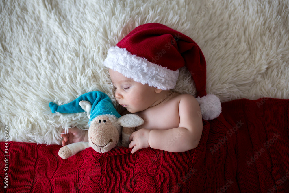 Obraz premium Little sleeping newborn baby boy, wearing Santa hat