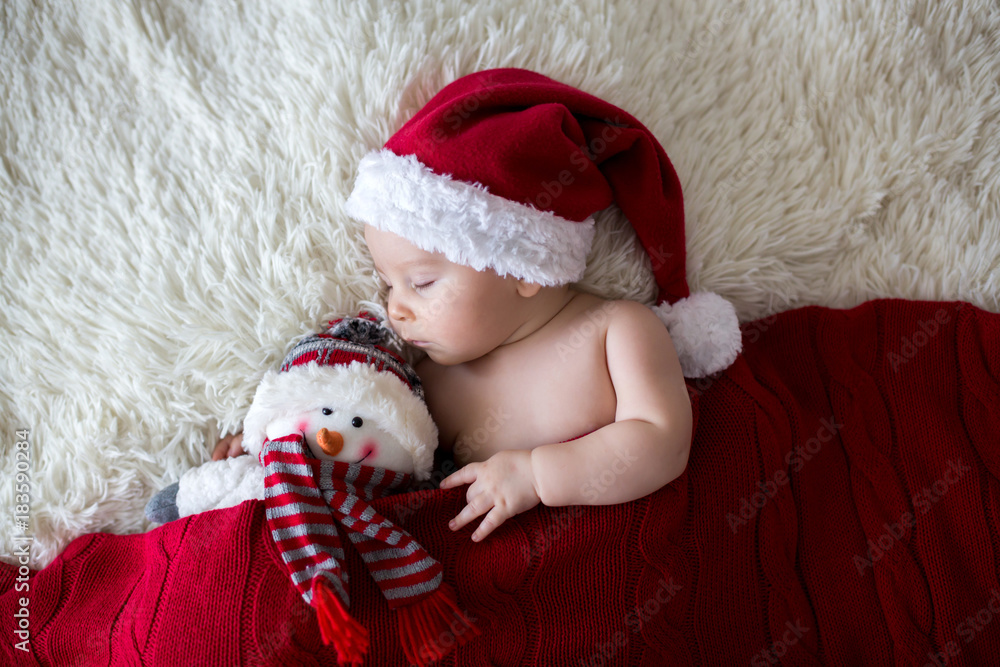 Obraz premium Little sleeping newborn baby boy, wearing Santa hat