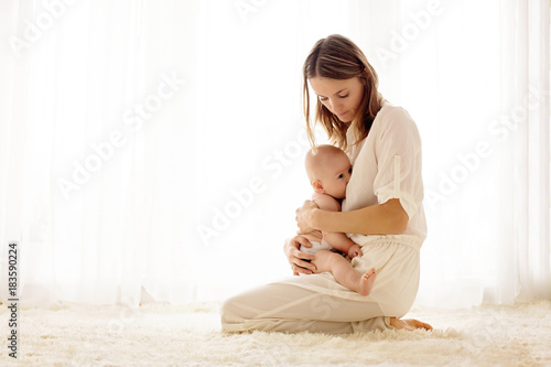Young mother breastfeeding her newborn baby boy