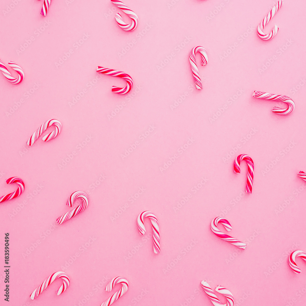 Christmas candy cane on pink background, copy space. Flat lay holiday concept. Christmas candy cane on pink background, copy space. Flat lay holiday concept.