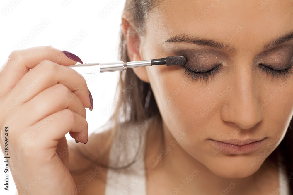 young beautiful woman applied eyeshadow on her eyelids young beautiful woman applied eyeshadow on her eyelids