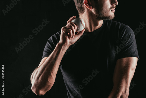 Canvas Print mid section of young man holding baseball ball isolated on black