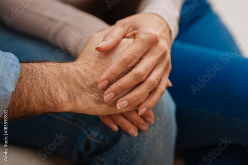 Love everywhere. Close up of young couples hands caught together placing them on the knees 