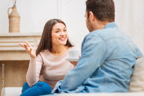 Unexpected end. Happy merry good looking woman laughing surprising and holding cup of tea