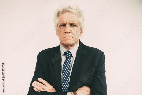 Portrait of displeased senior businessman in suit