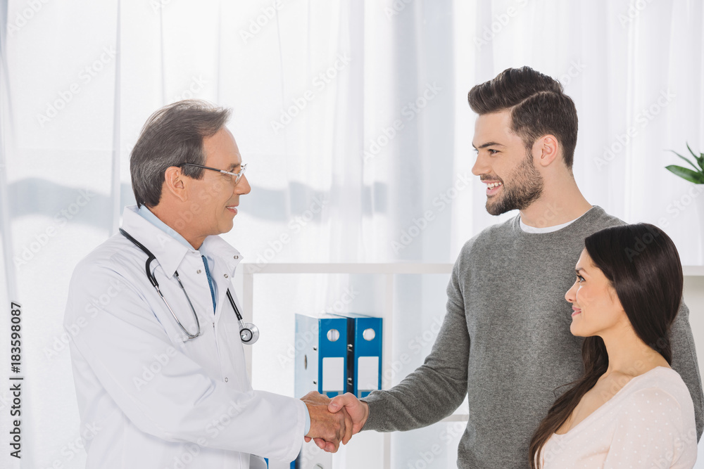 Obraz premium doctor and smiling patient shaking hands
