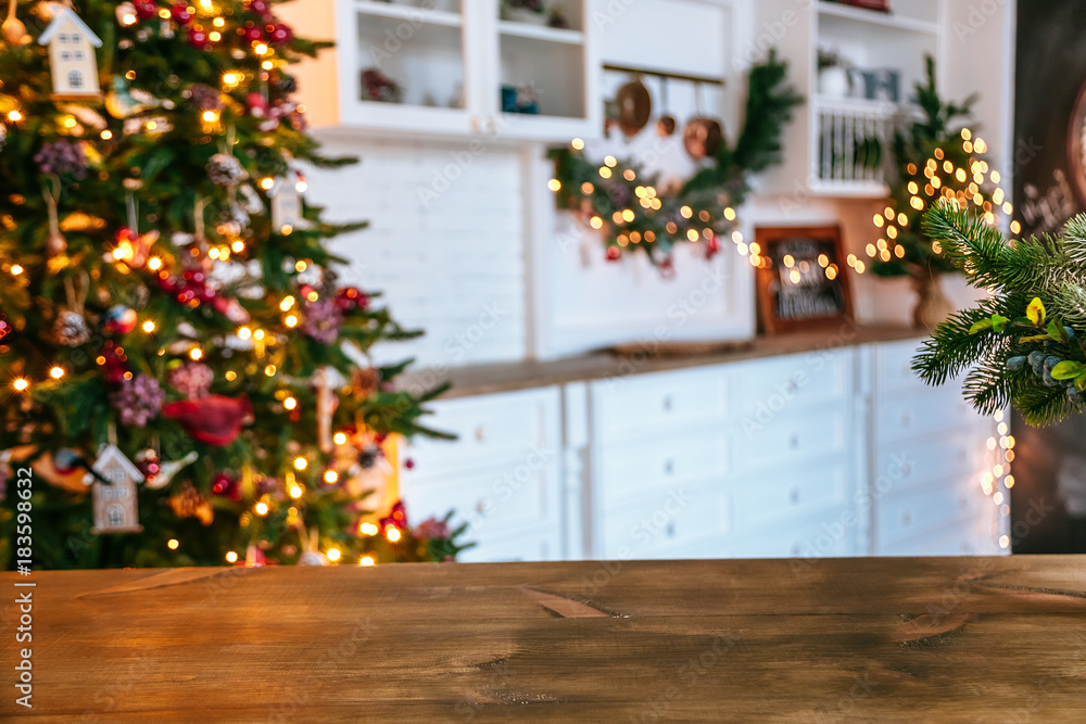 Christmas holiday background with empty rustic table and the bokeh of the living room with the Christmas tree on the second plan