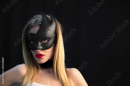 Mystic blonde woman in mask on dark background © Adriana Nikolova