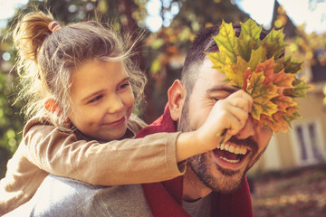 Happy family outside in colorful fall backyard.