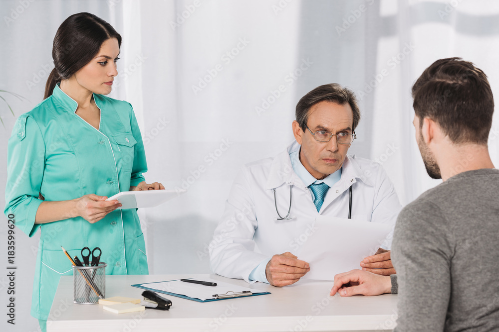 doctor talking to patient and nurse holding tablet doctor talking to patient and nurse holding tablet