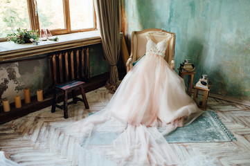 Shoes and wedding dress on chair in room