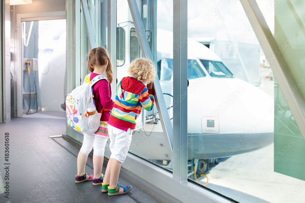 Kids travel and fly. Child at airplane in airport Kids travel and fly. Child at airplane in airport