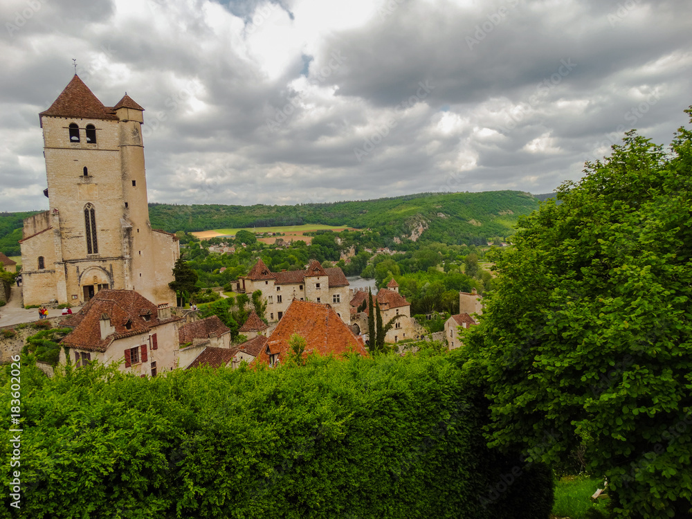 Saint Cirq Lapopie fortified medieval church in France on a cloudy day.