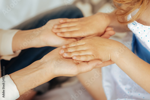 We are together. Close up of small childs hands being put on the adults hands while showing love