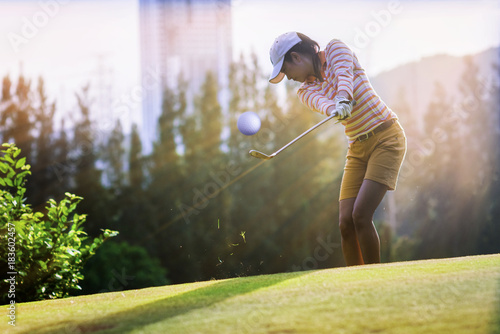 Fluffing of grass after woman golf player hit a golf ball from apron to the hole on the green of golf course photo