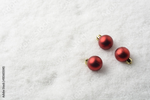 Bolas decorativas de navidad de color rojo en la nieve artificial