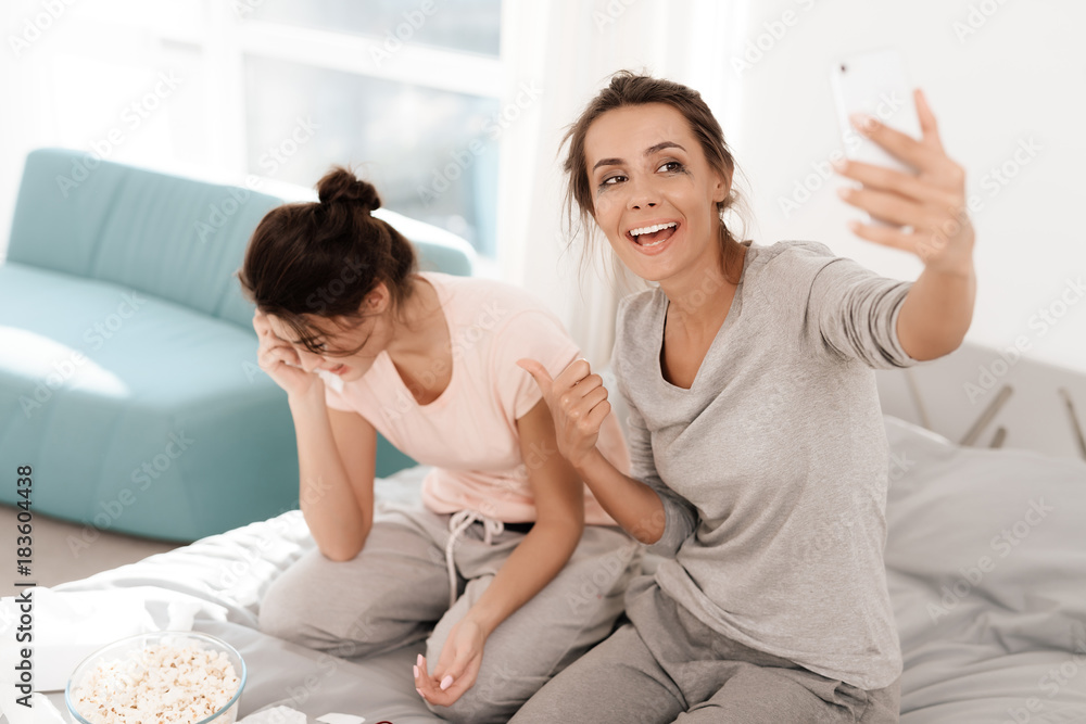 The girls are crying at the hen-party. They are sitting on the bed in room. Girls make selfie. The girls are crying at the hen-party. They are sitting on the bed in room. Girls make selfie.