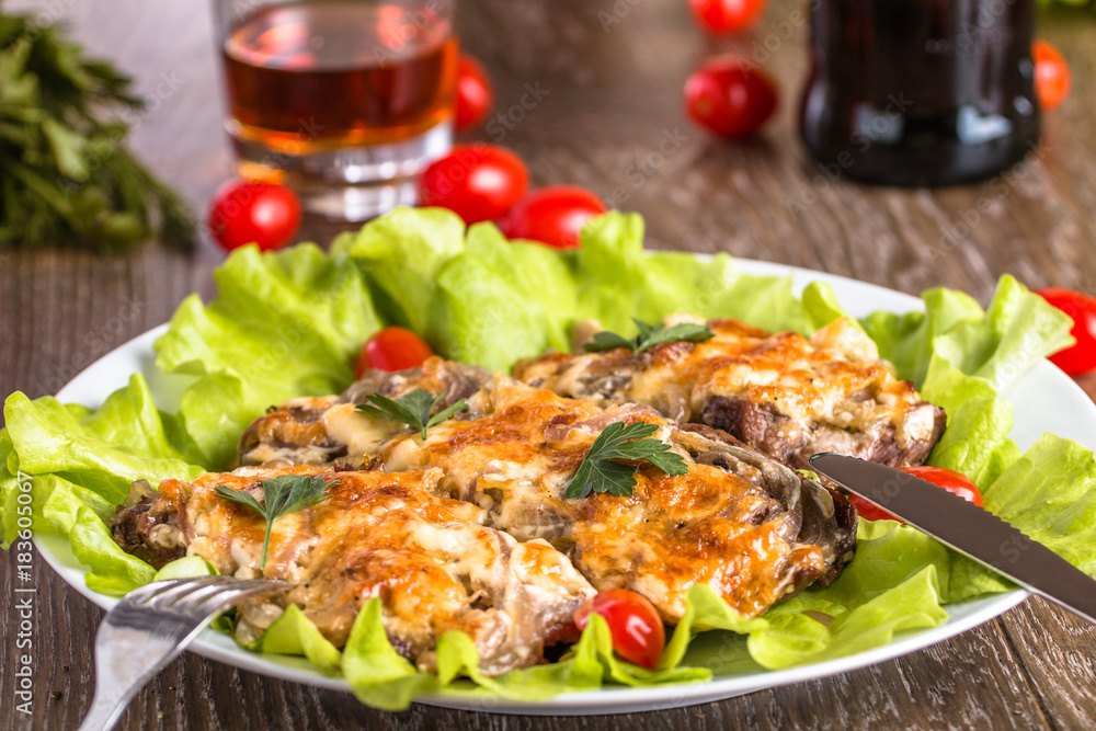 Baked meat with chopped onions and cheese on a salad leaf Baked meat with chopped onions and cheese on a salad leaf