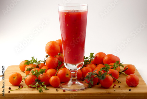 Tamoto Juice with pepper and cherry tomatoes on wooden plank isolated photo