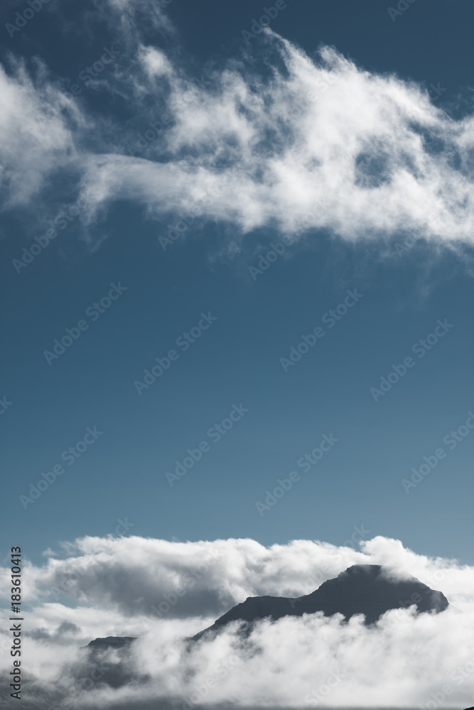 Obraz premium sommet de montage dans les nuages sur fond de ciel bleu